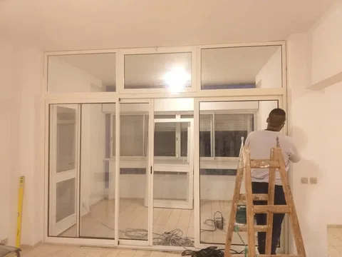 Cloison en aluminium blanc avec portes coulissantes vitrées et imposte, appartement à Rabat