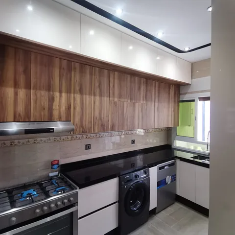 Cuisine sur mesure en bois et blanc laqué, avec électroménager encastré, région de Rabat