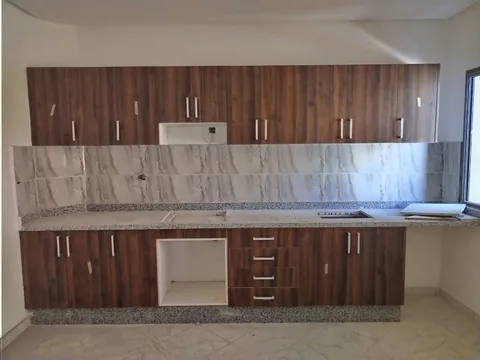 Cuisine sur mesure en bois foncé avec plan de travail en granit, région de Rabat