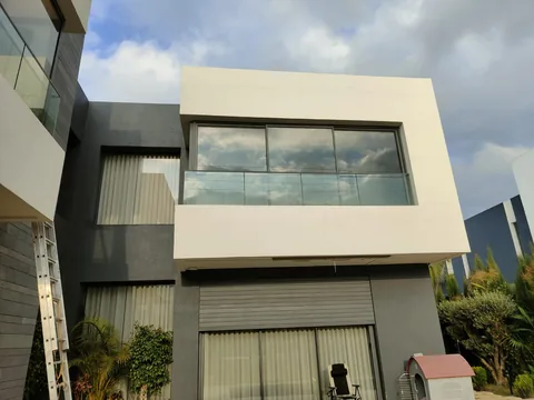 Façade de villa contemporaine avec baie vitrée d'angle à l'étage, région de Rabat