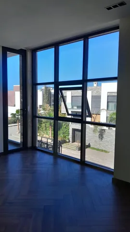 Baie vitrée d'angle en aluminium noir en double hauteur dans une villa, région de Rabat
