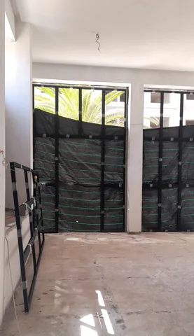 Grands châssis en aluminium noir en cours de pose dans une villa, région de Rabat