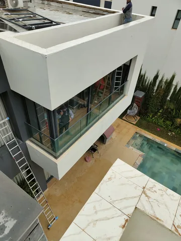 Balcon de villa avec garde-corps en verre au-dessus de la piscine, région de Rabat