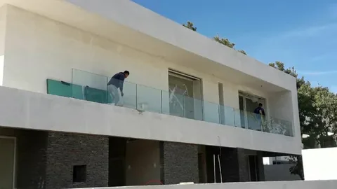 Garde-corps en verre en cours de pose sur le balcon d'une villa moderne, à Rabat