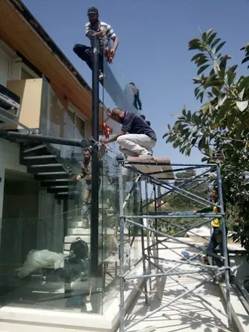 Pose d'un garde-corps en verre sur un escalier extérieur, depuis un échafaudage, à Rabat