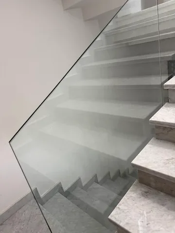 Garde-corps en verre sans montant le long d'un escalier intérieur en marbre, à Rabat