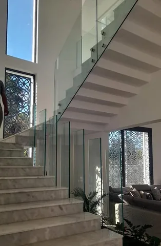 Garde-corps en verre fixé par pinces le long d'un escalier en marbre, villa à Rabat