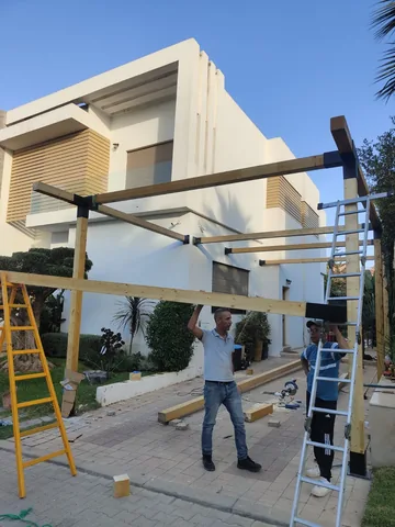 Montage de la structure d'une pergola devant une villa, région de Rabat