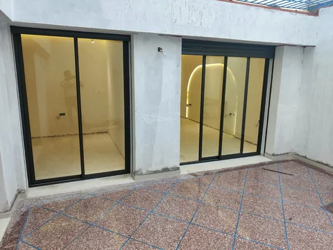 Portes-fenêtres en aluminium noir donnant sur un patio, région de Rabat