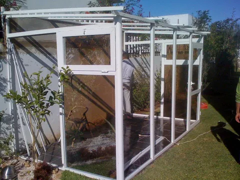 Véranda en aluminium blanc en cours de montage dans le jardin d'une villa, à Rabat