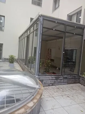 Véranda en aluminium gris fermant une cour de résidence, à Rabat