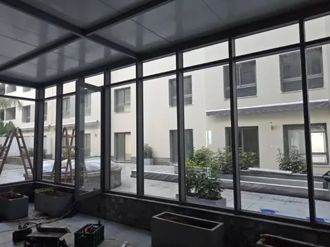 Véranda en aluminium noir avec toiture, vue intérieure sur une résidence, à Rabat