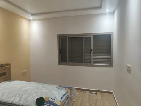 Fenêtre coulissante en aluminium avec volet roulant intégré dans une chambre, région de Rabat